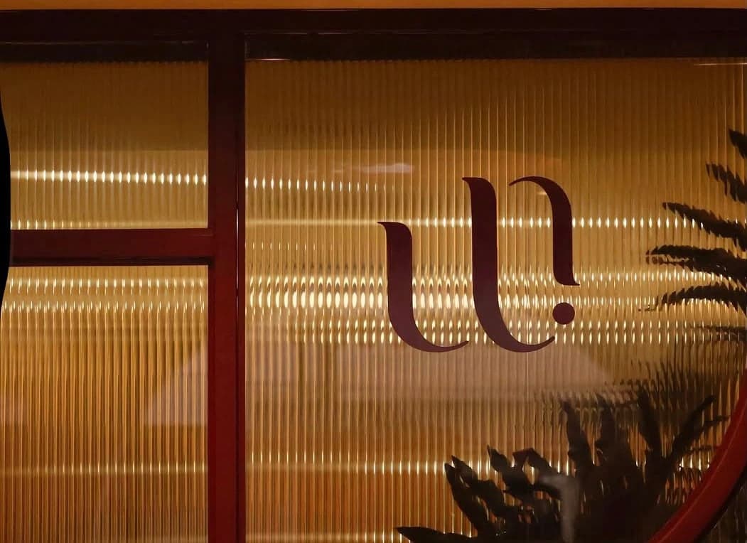 Logotipo de Uriarte sobre vidrio acanalado con luz ámbar