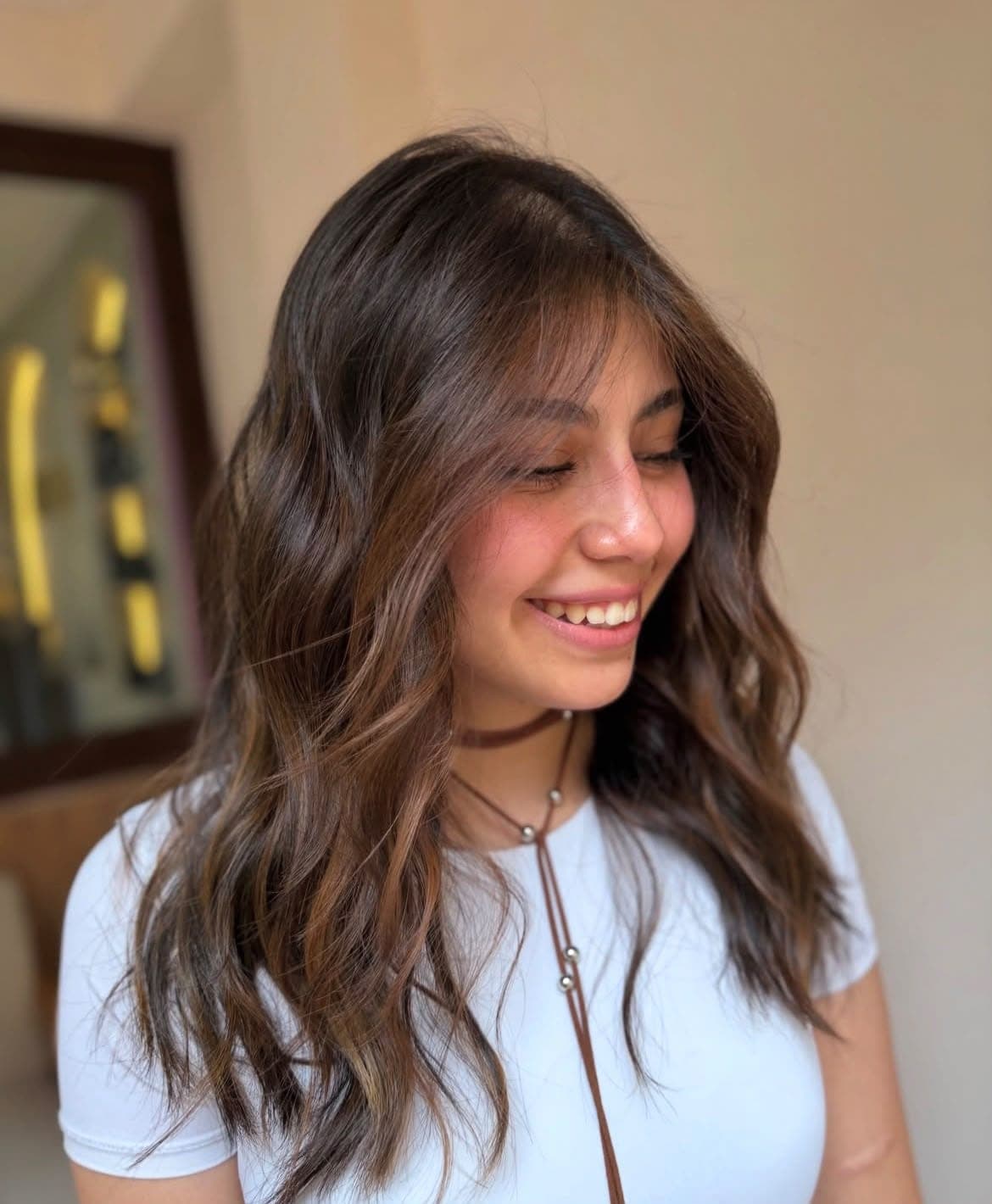 Clienta sonriendo con cabello ondulado y castaño